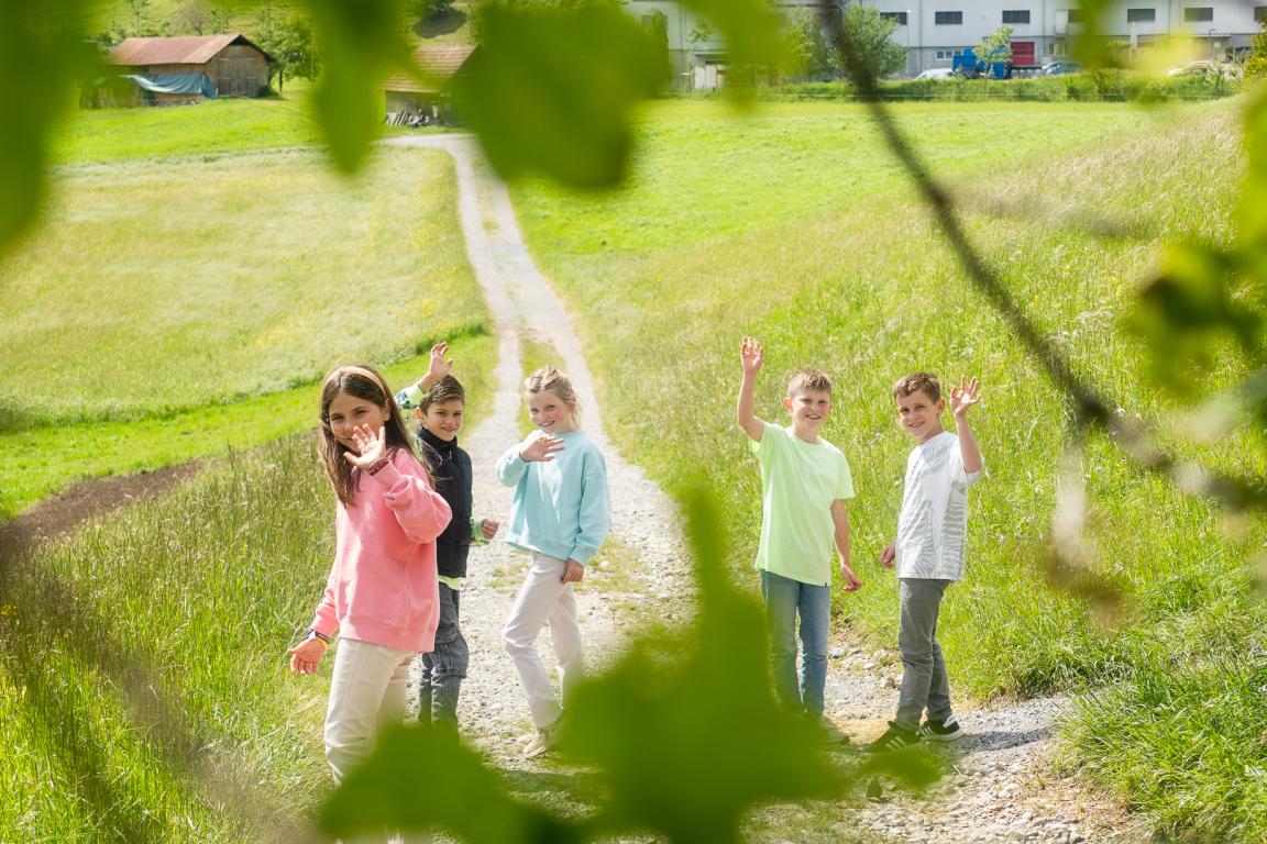 Fröhliche Kinder winken vor Chocolarium im Botsberger Riet